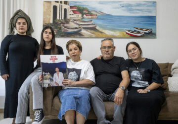 FILE - Sigi and Momi Cohen, flanked on the couch by their children Yuval, Michal, and Tamar, hold up a portrait of their 27-year-old son, Eliya Cohen, in the family house in the village of Tzur Hadassah, Israel, Oct. 30, 2023. Cohen, an Israeli citizen, was abducted by Hamas militants from the 