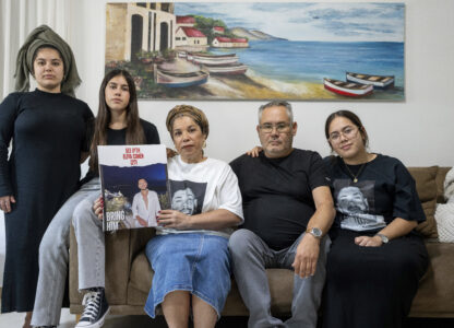 FILE - Sigi and Momi Cohen, flanked on the couch by their children Yuval, Michal, and Tamar, hold up a portrait of their 27-year-old son, Eliya Cohen, in the family house in the village of Tzur Hadassah, Israel, Oct. 30, 2023. Cohen, an Israeli citizen, was abducted by Hamas militants from the 