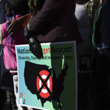 FILE - A community member holds a sign calling for a national boycott of Target stores during a news conference outside Target Corporation's headquarters Thursday, Jan. 30, 2025, in Minneapolis, Minn. (AP Photo/Ellen Schmidt, File)