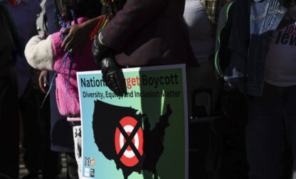 FILE - A community member holds a sign calling for a national boycott of Target stores during a news conference outside Target Corporation's headquarters Thursday, Jan. 30, 2025, in Minneapolis, Minn. (AP Photo/Ellen Schmidt, File)