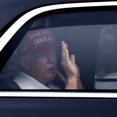 President Donald Trump waves from his vehicle as he arrives at the Trump International Golf Club, Monday, Feb. 17, 2025, in West Palm Beach, Fla. (AP Photo/Ben Curtis)