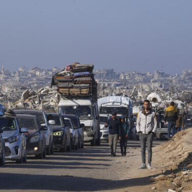 Displaced Palestinians, traveling in vehicles, wait to cross through a security checkpoint at the Netzarim corridor as they make their way from central Gaza to the northern Gaza Strip, Tuesday, Feb. 18, 2025. (AP Photo/Abdel Kareem Hana)