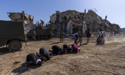 Lebanese men pray after they entered their destroyed hometown of Kfar Kila, southern Lebanon, Tuesday, Feb. 18, 2025. (AP Photo/Hassan Ammar)