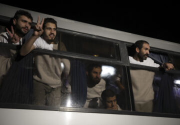 Freed Palestinian prisoners flash V-signs as they arrive in the Gaza Strip after being released from an Israeli prison following a ceasefire agreement between Hamas and Israel in Khan Younis, Gaza Strip, Thursday, Feb. 27, 2025. (AP Photo/Jehad Alshrafi)