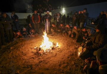 Relatives and friends of Palestinian prisoners to be released from Israeli prison wait around a bonfire for their arrival in Khan Younis, southern Gaza Strip, late Wednesday Feb. 26, 2025. (AP Photo/Jehad Alshrafi)