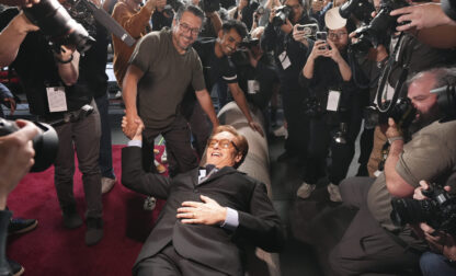 Conan O'Brien, host of Sunday's 97th Academy Awards, poses atop the red carpet during the annual red carpet roll out at the Dolby Theatre on Wednesday, Feb. 26, 2025, in Los Angeles. (AP Photo/Chris Pizzello)