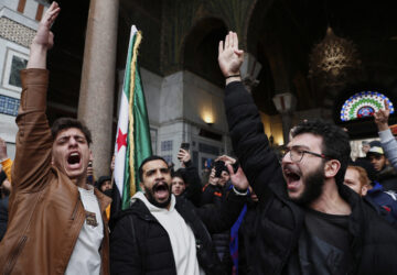 Syrian government supporters shout slogans to show their solidarity with the security forces who are fighting against gunmen loyal to former President Bashar Assad during a protest in Damascus, Syria, Friday, March 7, 2025. (AP Photo/Omar Sanadiki)