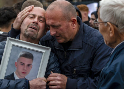 Dragi Stojanov, left, cries holding a photograph of his son Tomche Stojanov, one of the victims of a massive nightclub fire, during a vigil joined by hundreds in the town of Kocani, North Macedonia, Monday, March 17, 2025. (AP Photo/Visar Kryeziu)