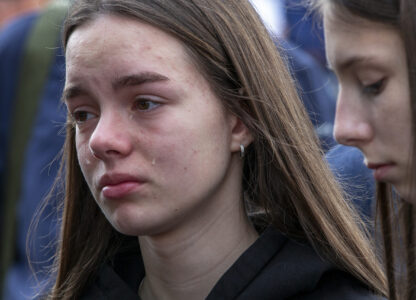 A girl cries as she wait in line to write condolence messages for the victims of a massive nightclub fire in the town of Kocani, North Macedonia, Monday, March 17, 2025. (AP Photo/Visar Kryeziu)