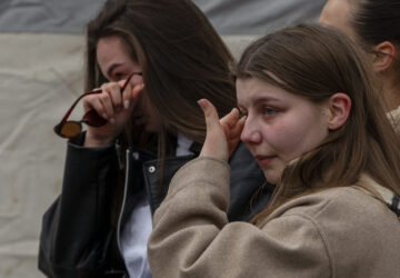 Women cry and wait in line to write condolence messages for the victims of a massive nightclub fire in the town of Kocani, North Macedonia, Monday, March 17, 2025. (AP Photo/Visar Kryeziu)