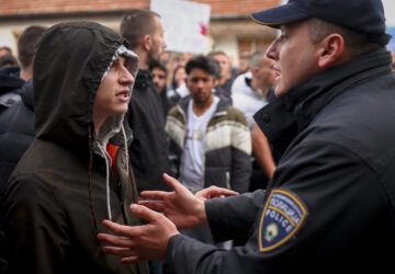 People argue with policemen, outside the home of the owner of a nightclub that was the scene of a massive fire, after a vigil for the victims in the town of Kocani, North Macedonia, Monday, March 17, 2025. (AP Photo/Armin Durgut)