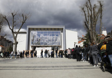 People wait in line to write condolence messages for the victims of a massive nightclub fire in the town of Kocani, North Macedonia, Monday, March 17, 2025. (AP Photo/Boris Grdanoski)