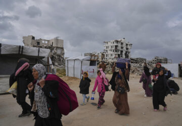 Displaced Palestinians, carrying their belongings, move away from the areas where the Israeli army is operating after Israel's renewed offensive in the Gaza Strip, on the outskirts of Beit Lahia, Thursday, March 20, 2025. (AP Photo/Jehad Alshrafi)