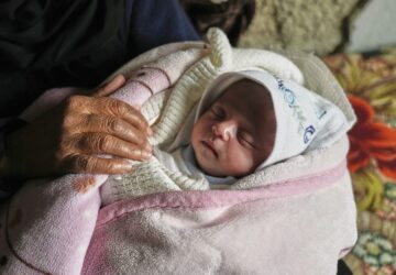 Ella Osama Abu Dagga, 25 days old, is held by her great-aunt Suad Abu Dagga, after she was pulled from the rubble earlier following an Israeli army airstrike that killed her parents and brother, in Khan Younis, southern Gaza Strip, Thursday, March 20, 2025. (AP Photo/Abdel Kareem Hana )