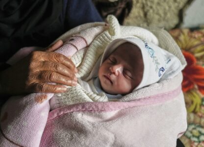 Ella Osama Abu Dagga, 25 days old, is held by her great-aunt Suad Abu Dagga, after she was pulled from the rubble earlier following an Israeli army airstrike that killed her parents and brother, in Khan Younis, southern Gaza Strip, Thursday, March 20, 2025. (AP Photo/Abdel Kareem Hana )