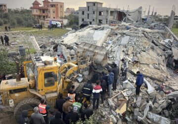 Volunteers and rescue workers use a bulldozer as to remove the rubble of a building hit by an Israeli army airstrike in Khan Younis, southern Gaza Strip, Thursday, March 20, 2025. (AP Photo/Mariam Dagga)