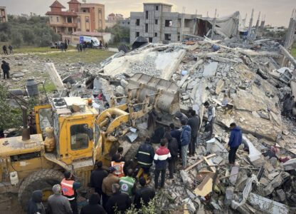 Volunteers and rescue workers use a bulldozer as to remove the rubble of a building hit by an Israeli army airstrike in Khan Younis, southern Gaza Strip, Thursday, March 20, 2025. (AP Photo/Mariam Dagga)