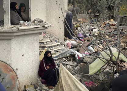 Neighbours watch as volunteers and rescue workers search for survivors among the rubble of a building hit by an Israeli army airstrike in Khan Younis, southern Gaza Strip, Thursday, March 20, 2025. (AP Photo/Mariam Dagga)