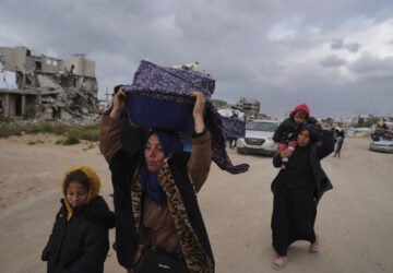 Displaced Palestinians, carrying their belongings, move away from the areas where the Israeli army is operating after Israel's renewed offensive in the Gaza Strip, on the outskirts of Beit Lahia, Thursday, March 20, 2025. (AP Photo/Jehad Alshrafi)