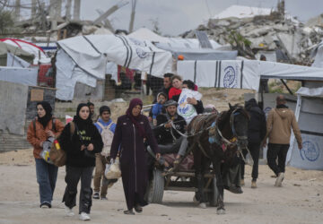 Displaced Palestinians, carrying their belongings, move away from the areas where the Israeli army is operating after Israel's renewed offensive in the Gaza Strip, on the outskirts of Beit Lahia, Thursday, March 20, 2025. (AP Photo/Jehad Alshrafi)