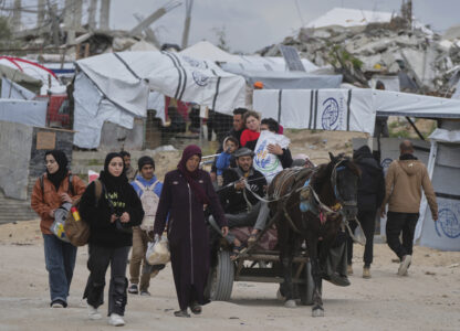 Displaced Palestinians, carrying their belongings, move away from the areas where the Israeli army is operating after Israel's renewed offensive in the Gaza Strip, on the outskirts of Beit Lahia, Thursday, March 20, 2025. (AP Photo/Jehad Alshrafi)