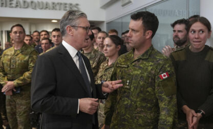 Britain's Prime Minister Keir Starmer speaks to a Canadian Lt Colonel as he visits a military base to meet planners mapping out next steps in the Coalition of the Willing in Northwood, London, Thursday, March 20, 2025.(AP Photo/Alastair Grant, Pool)